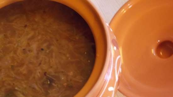 Lean cabbage soup with cabbage, beans, mushrooms and prunes under a bread lid