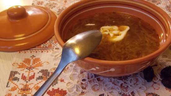 Lean cabbage soup with cabbage, beans, mushrooms and prunes under a bread lid