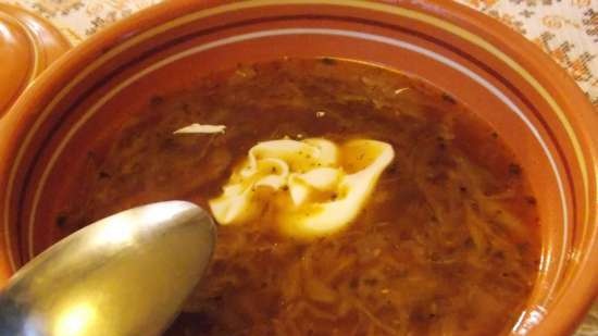 Lean cabbage soup with cabbage, beans, mushrooms and prunes under a bread lid