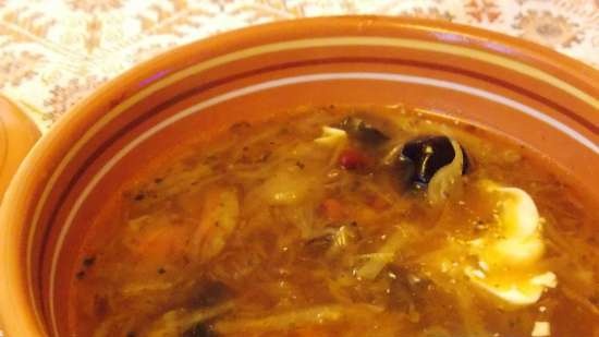 Lean cabbage soup with cabbage, beans, mushrooms and prunes under a bread lid